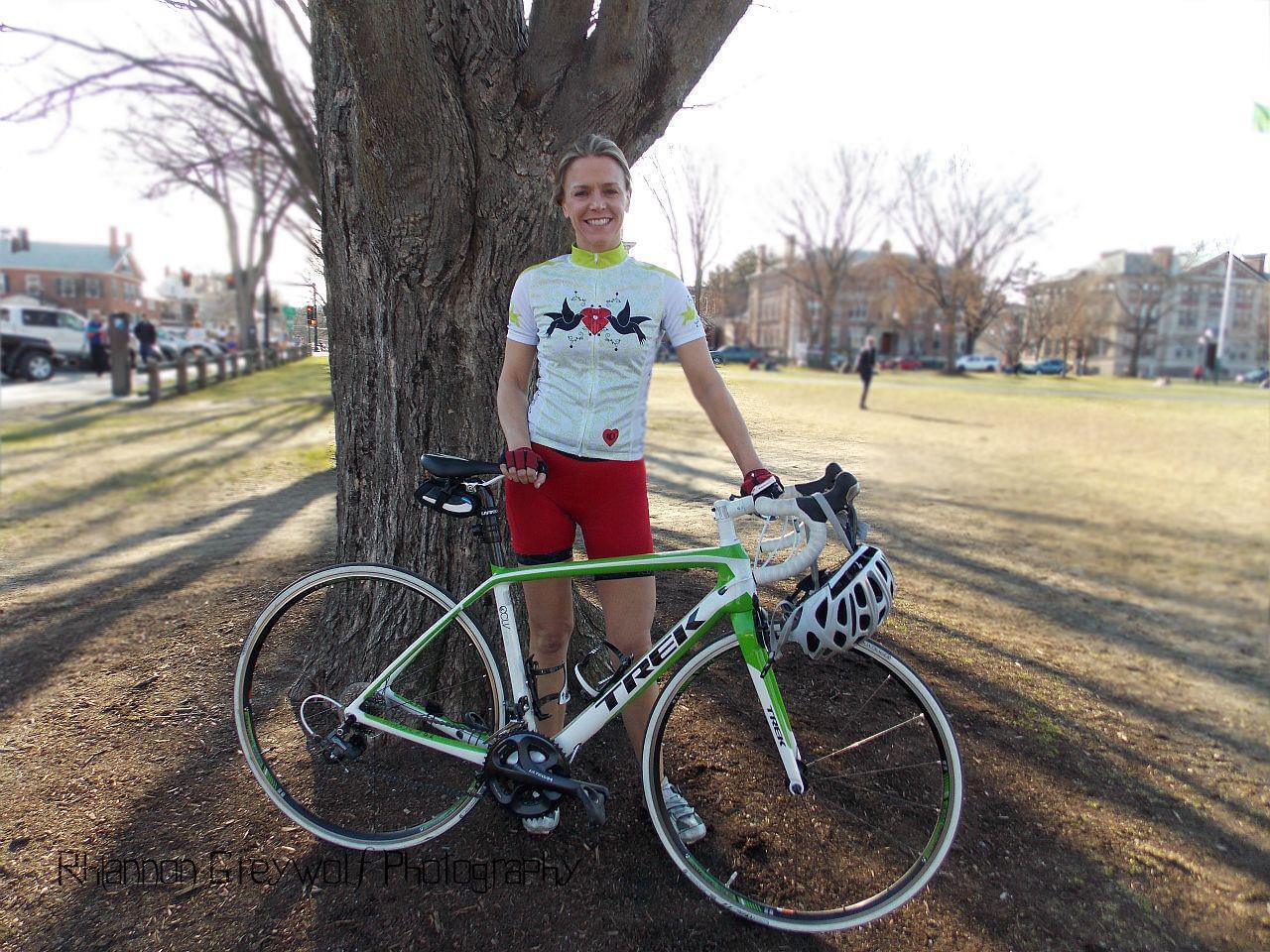 Kelley Dole standing with her road bike under a tree in a park